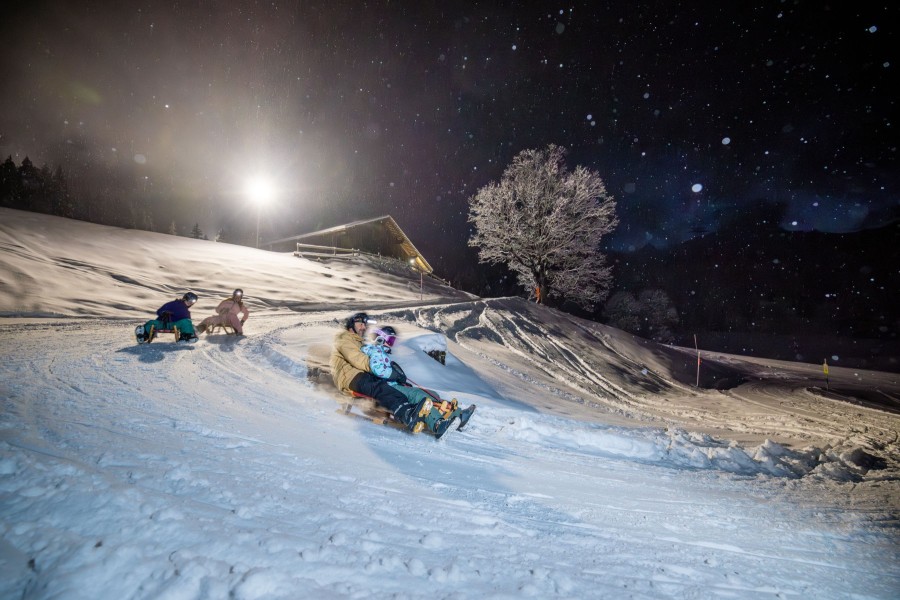 Ein Highlight bei Tag und bei Nacht: Schlitteln in der Jungfrau Ski Region.