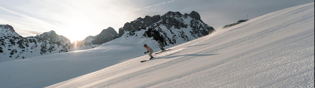 Perfekt präparierte Pisten und Sonne pur – im Tannheimer Tal genießen Skifahrer schwungvolle Abfahrten inmitten einer beeindruckenden Bergkulisse.