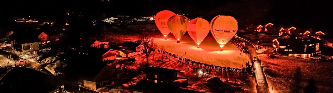 Leuchtende Ballons vor nächtlicher Bergkulisse – beim Ballonglühen im Tannheimer Tal wird der Winterhimmel zur funkelnden Bühne.
