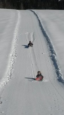 Kinder rutschen über Hof-Rodelbahn