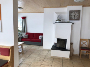Wohnzimmer mit Couchecke und Holzofen