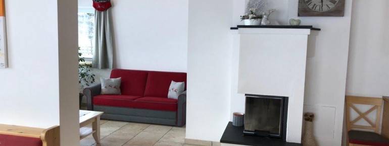 Wohnzimmer mit Couchecke und Holzofen