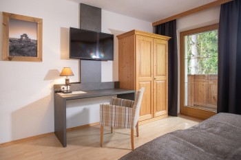 Schlafzimmer mit Schreibtisch und Fernseher