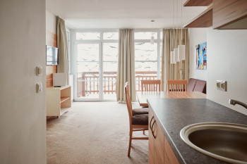 Der Wohnbereich besteht aus einer Sitzecke, einem Sofa, einem TV und dem Balkon.