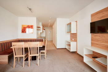 Der Wohnbereich besteht aus einer Sitzecke, einem Sofa, einem TV und dem Balkon.