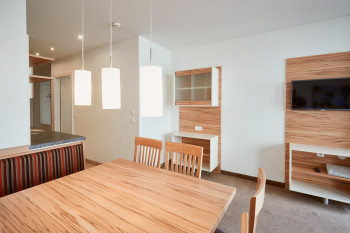 Der Wohnbereich besteht aus einer Sitzecke, einem Sofa, einem TV und dem Balkon.
