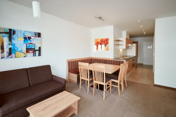 Der Wohnbereich besteht aus einer Sitzecke, einem Sofa, einem TV und dem Balkon.