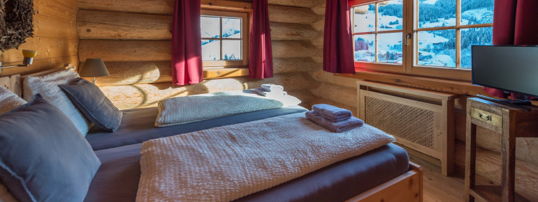 Schlafzimmer mit Bergpanorama im Hüttendorf Maria Alm
