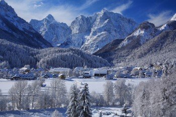 So lässt sich der Winter genießen - verschneite Wipfel und Dächer und die Berge im Hintergrund.