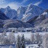 So lässt sich der Winter genießen - verschneite Wipfel und Dächer und die Berge im Hintergrund.