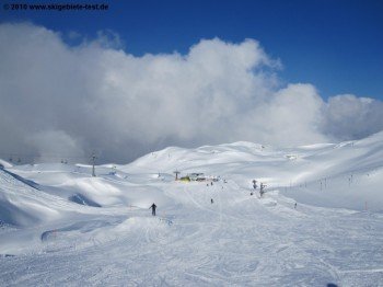 Unterer Teil der kurzen blauen Abfahrt von der Bergstation zu Übungslift und Sessellift.
