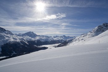 Über präparierte Pisten hinweg blickt man auf die Engadiner Seen und die Ortschaften Silvaplana, Surlej und Champfer.